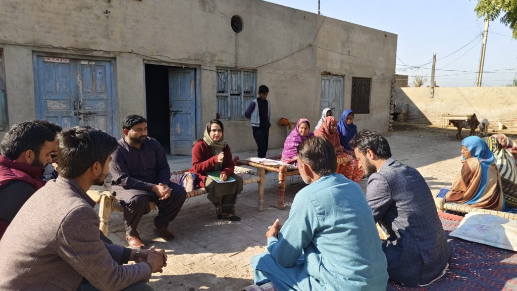 Farwah surrounded by men and women farmers.